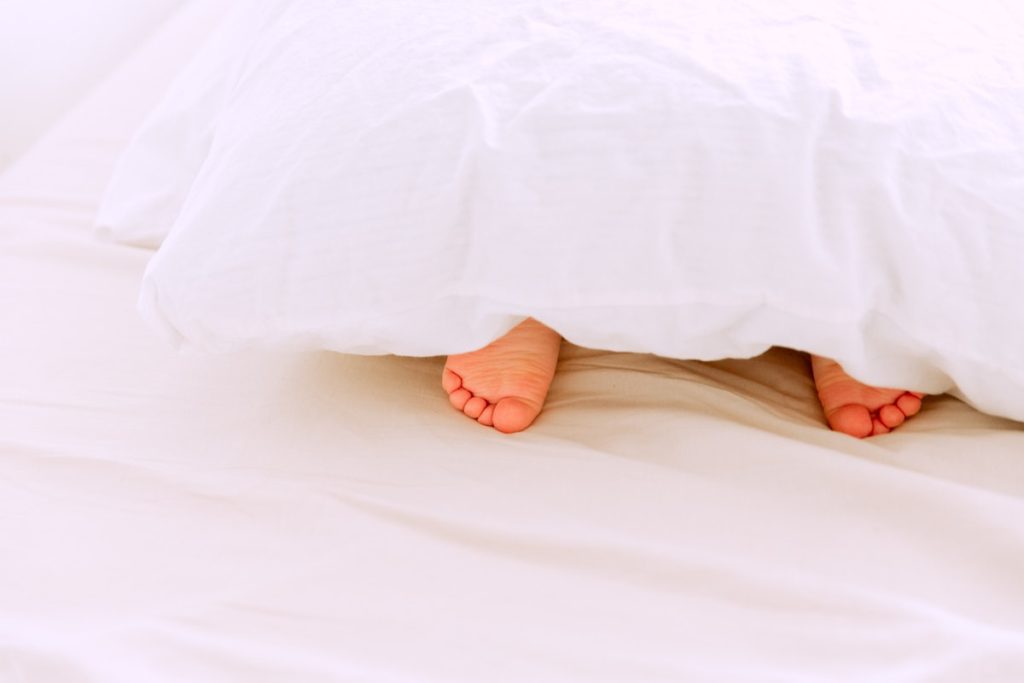 Toes peeking out from under a comforter