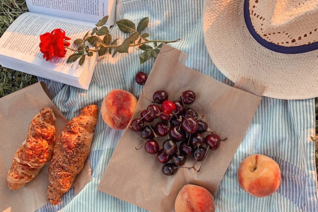 Picnic lunch, hat, and journal on a blanket