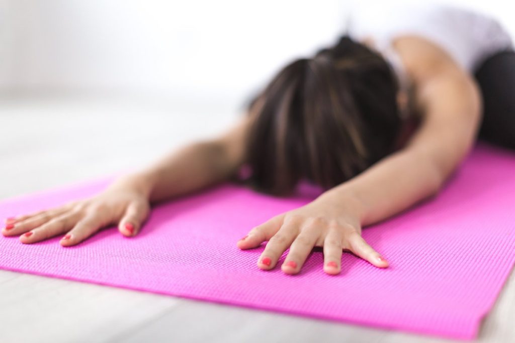 Yoga child's pose on pink mat